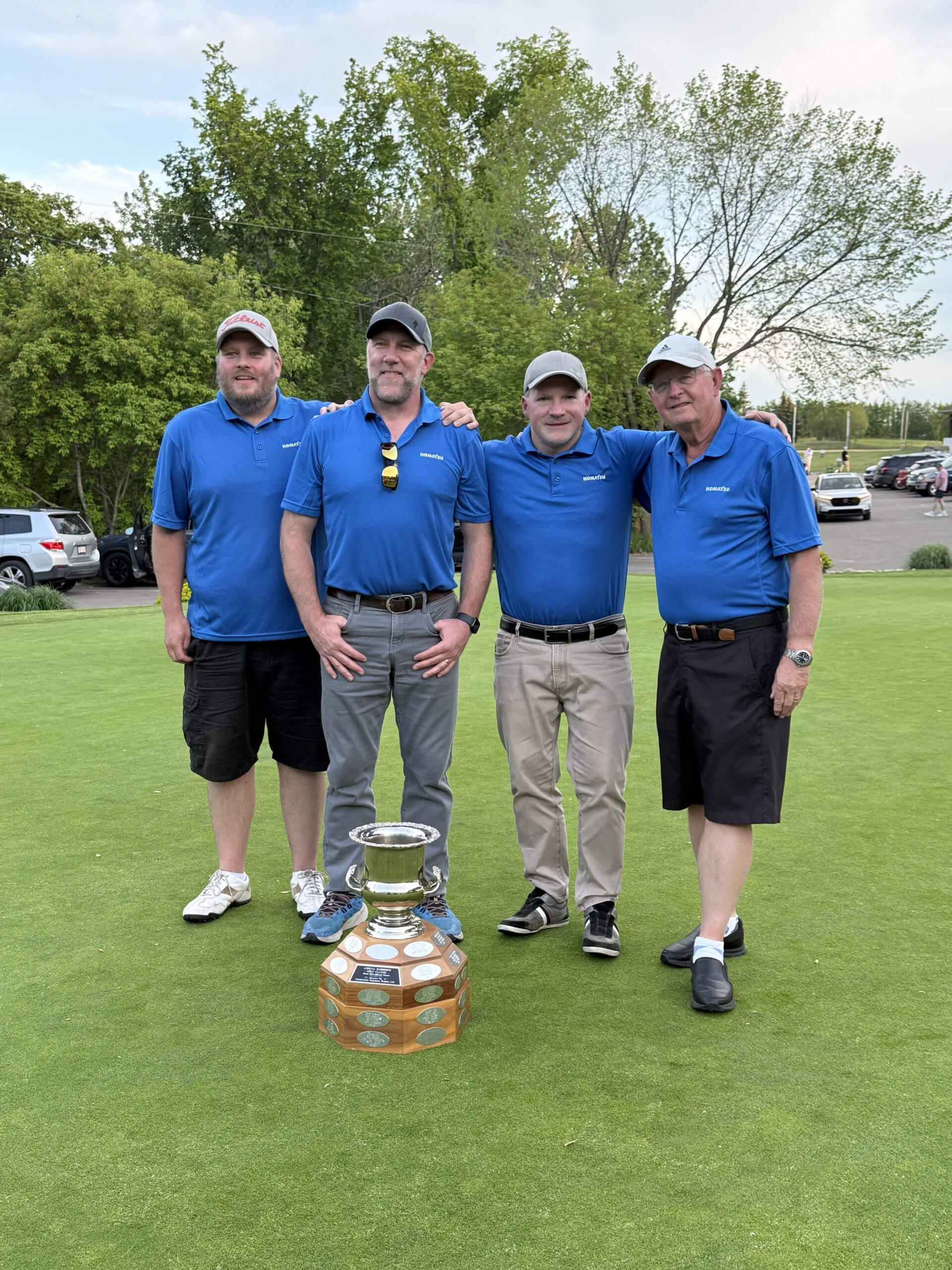 Golf team holding trophy on green